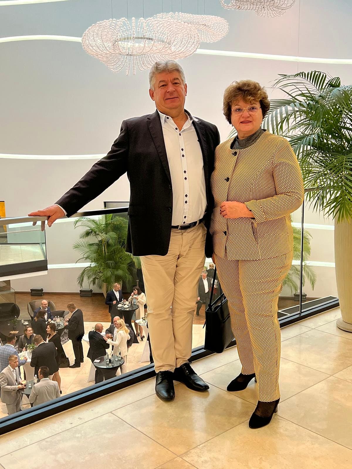 Larissa Etzel und ein Begleiter auf einer Galerie, unten ein festlich eingerichteter Saal.