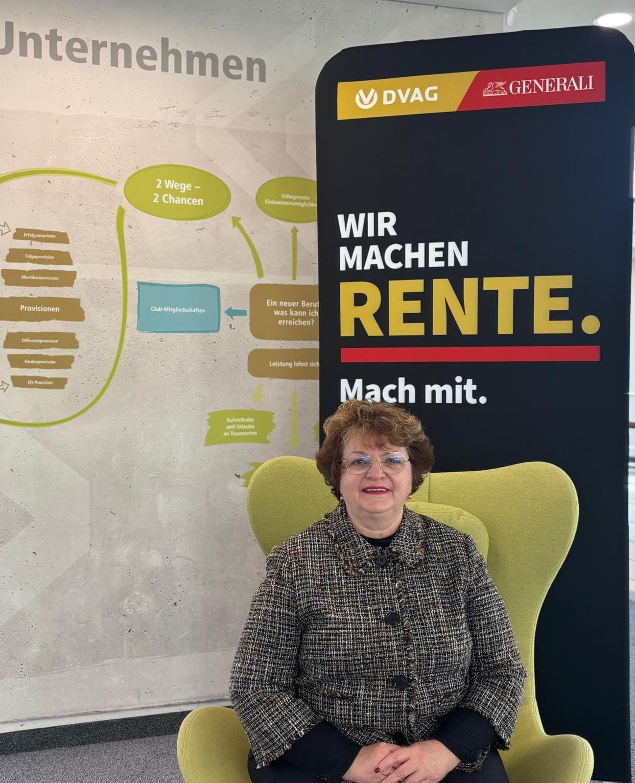 Larissa Etzel sitzt lächelnd in einem grünen Sessel, hinter ihr ein Aufsteller „Wir machen Rente. Mach mit.“